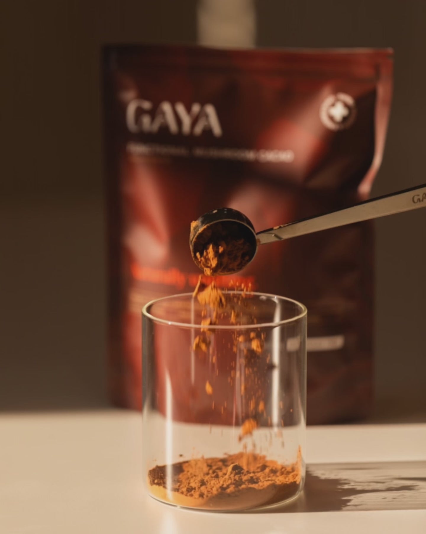 Close-up of GAYA cacao powder falling into glass, highlighting texture and preparation of functional mushroom coffee alternative