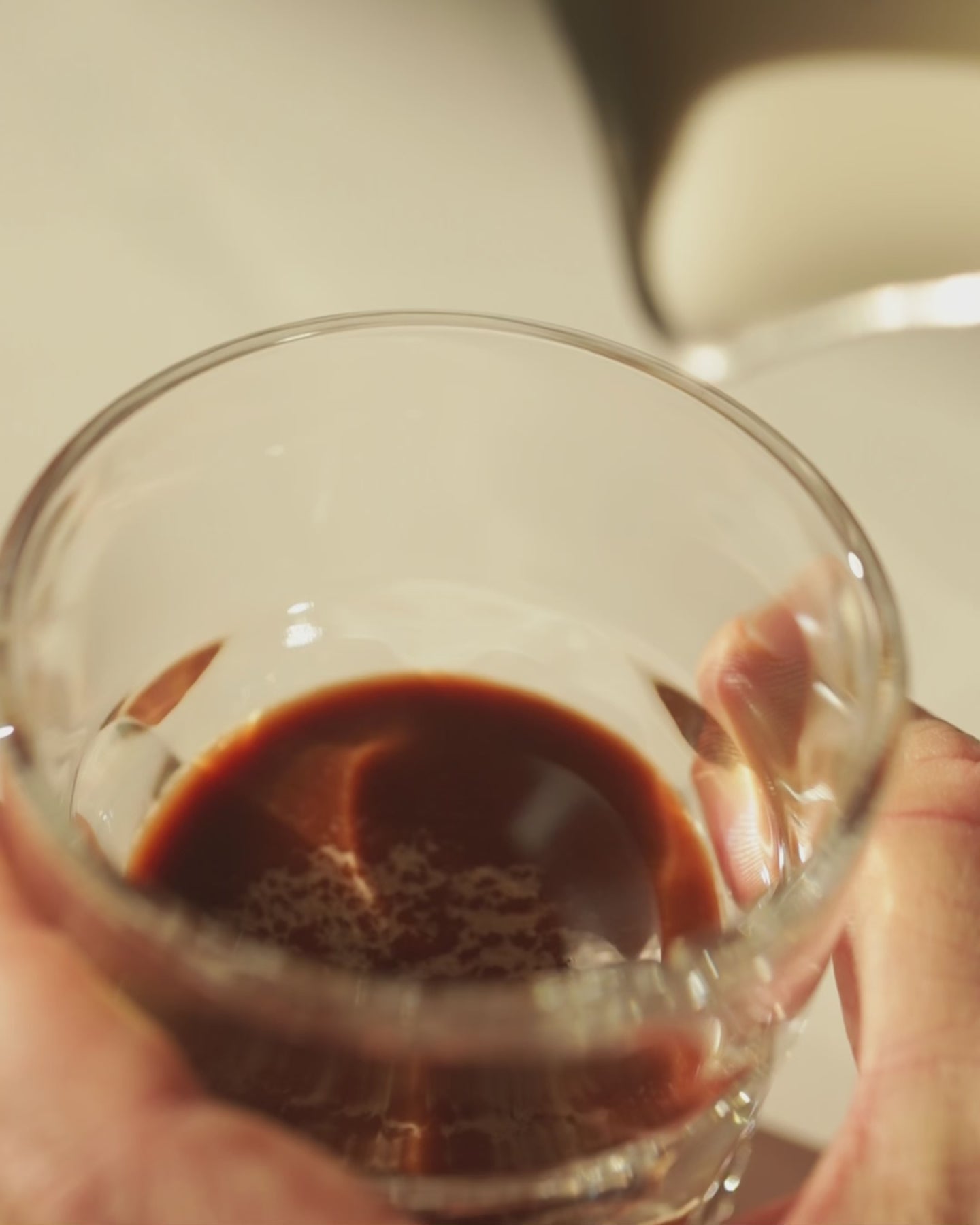 Milk being poured into cacao drink in glass, demonstrating preparation of functional mushroom coffee alternative