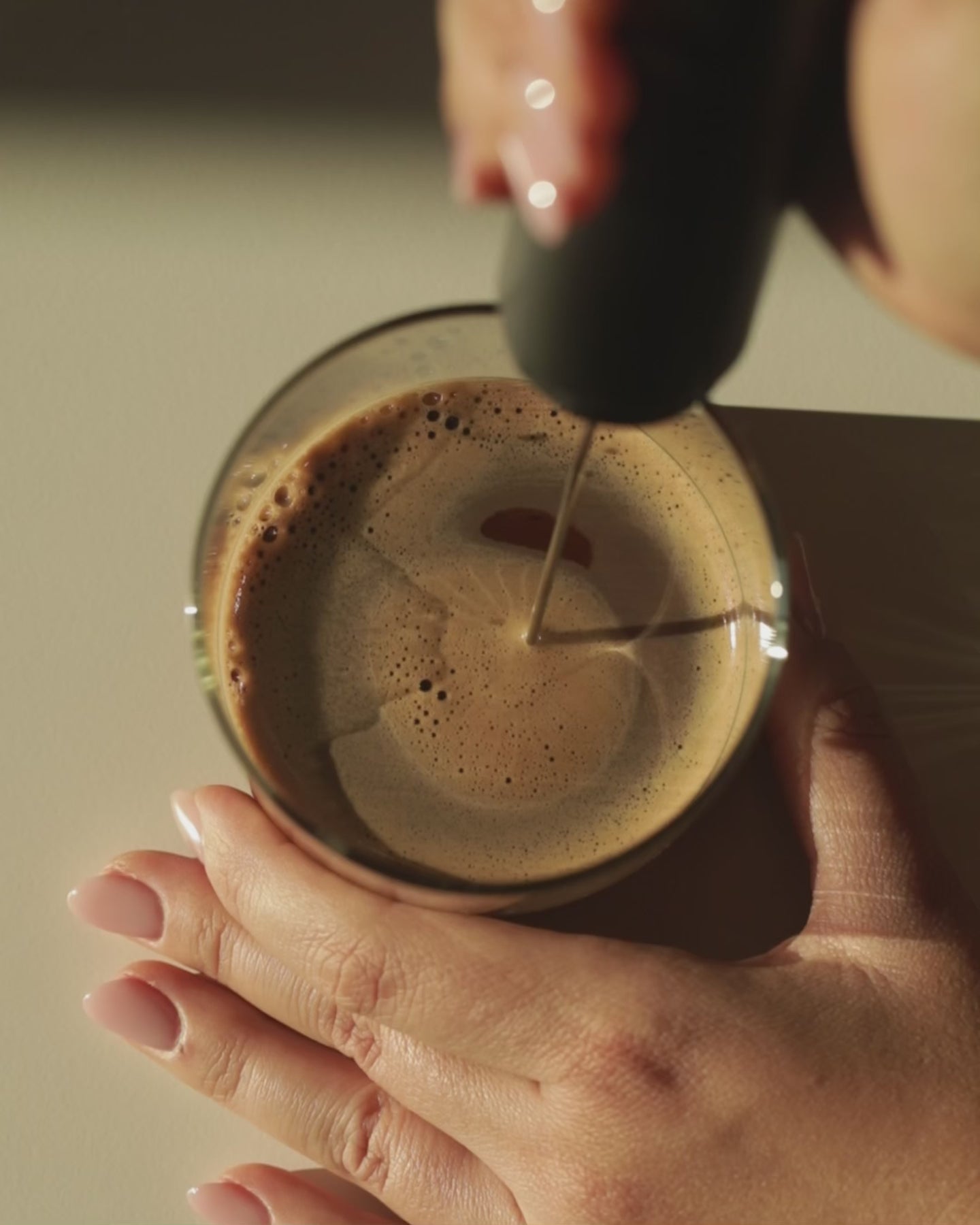 Functional mushroom cacao being mixed and frothed in glass, demonstrating preparation of natural coffee alternative drink